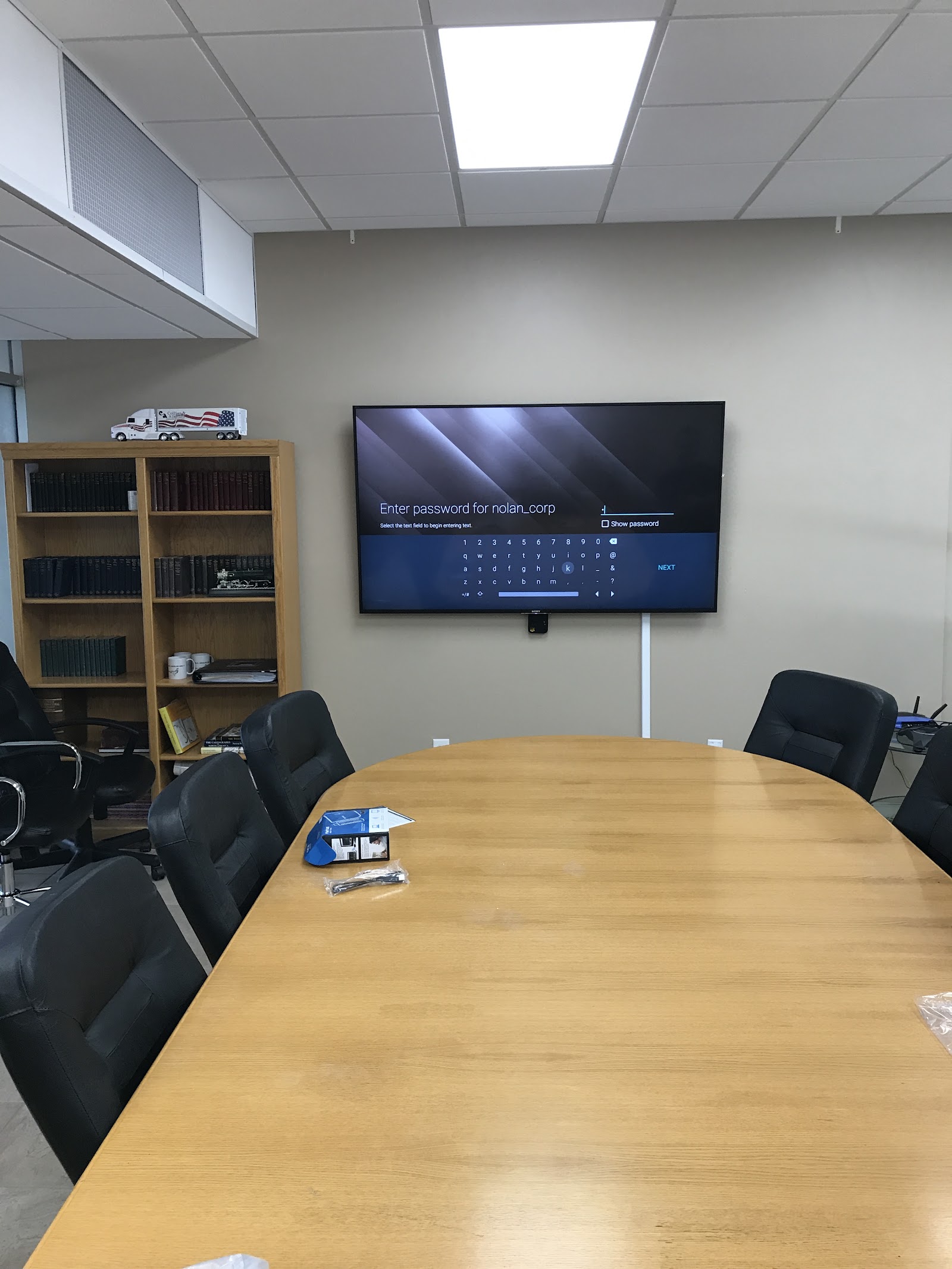 Large-format display mounted in a conference room with seating for a professional AV installation